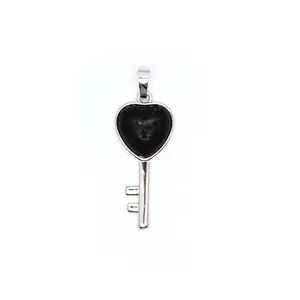 Close-up detail of a silver heart-shaped key pendant featuring black natural stone