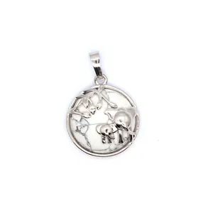 Vue détaillée d'un pendentif éléphant argenté avec incrustation de pierre de marbre blanc.