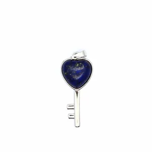 Detail showing the heart-shaped blue gemstone set in a silver-colored key pendant.