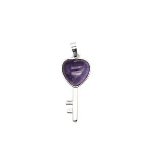 Detailed close-up view of a heart-shaped purple crystal key pendant with a silver finish
