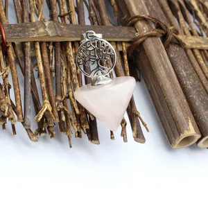 Detailed close-up of pink quartz Tree of Life pendulum pendant displayed on bamboo backdrop