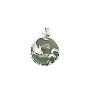 Detailed macro view of silver-tone dolphin and wave pendant with green aventurine stone