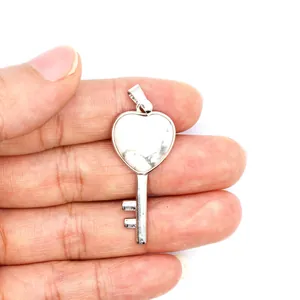 Macro detail of a silver-toned heart-shaped key pendant with white pine stone inlay