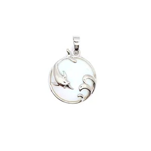Detail view of silver dolphin and ocean wave pendant with white mother-of-pearl inlay