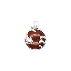 Macro view of a silver dolphin playing in waves over a polished red aventurine jade stone