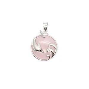 Close-up detail of rose quartz dolphin pendant with silver wave motif on white background.