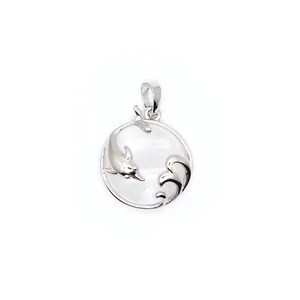 Close-up detail of silver dolphin and wave pendant featuring a clear round crystal center