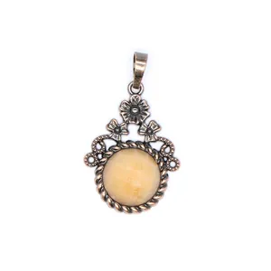 Dettaglio del design floreale e della pietra naturale gialla del ciondolo stile vintage