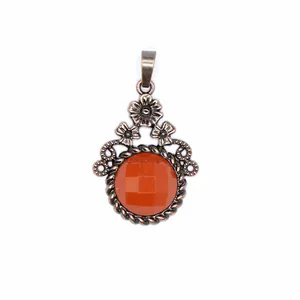Primo piano di un ciondolo in bronzo retrò con fiori e pietra di agata arancione sfaccettata