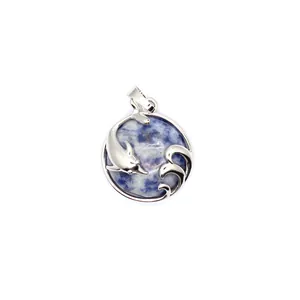 Detailed macro view of a silver dolphin and wave pendant with blue sodalite stone