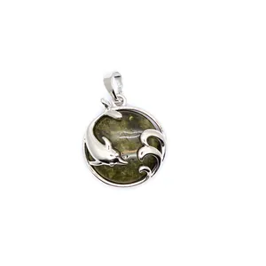 Close-up of dolphin and wave silver pendant with natural green aventurine stone.