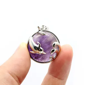Close-up view of a circular purple crystal pendant featuring an intricate silver dolphin design