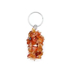 Close-up of irregular orange crystal crushed stone pendant on a silver keychain.