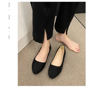 Detailansicht eleganter schwarzer spitzer Wildleder-Flachschuhe mit Schlitz-Hose kombiniert