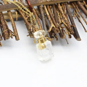 Vue détaillée d'un pendentif flacon de parfum en cristal sur une fine chaîne dorée