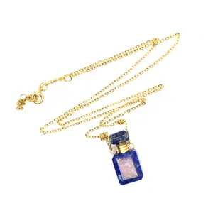 Détail rapproché d'un délicat collier avec pendentif bouteille de parfum bleue