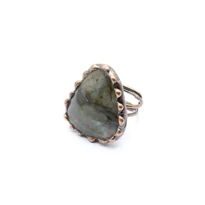 Detailed close-up of a vintage labradorite raw stone ring with a copper beaded bezel
