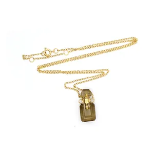 Vue détaillée d'un pendentif en cristal en forme de flacon de parfum sur chaîne dorée