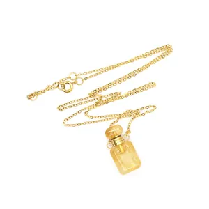 Détail du pendentif flacon de parfum en cristal de citrine sur collier chaîne dorée
