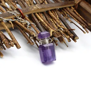 Détail macro d'un pendentif flacon de parfum en cristal violet sur une chaîne en argent