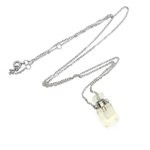 Gros plan d'un collier flacon de parfum en cristal avec pendentif quartz citron