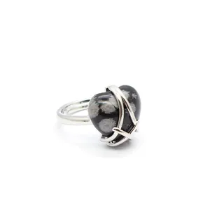 Macro view of a heart-shaped snowflake obsidian stone set in a sleek silver ring band