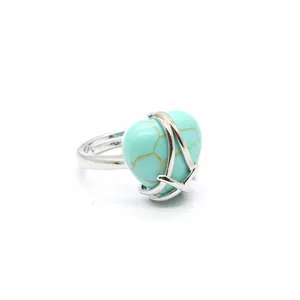Detailed view of a turquoise heart-shaped stone ring with silver wrap-around band