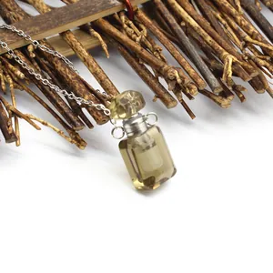 Détail d'un pendentif flacon de parfum en cristal de citron sur une chaîne en argent