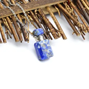 Détail du collier flacon de parfum en cristal lapis-lazuli sur fond en bois.