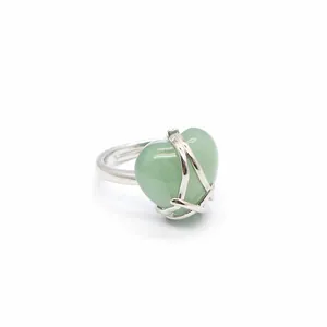 Detailed shot of a silver-toned ring featuring a green heart-shaped gemstone detail