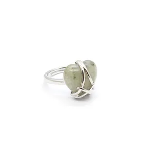 Close-up of heart-shaped green stone ring with silver adjustable band and unique claw setting