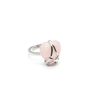 Close-up detail of a silver-toned adjustable ring with a pink heart opal-like stone