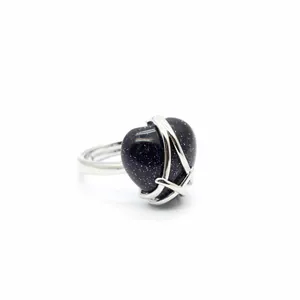 Detailed macro view of a dark blue heart-shaped sandstone ring with silver metal wrap