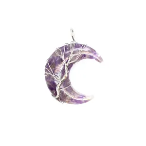 Zoom sur un pendentif croissant de lune avec éclats d'améthyste et fil d'argent torsadé