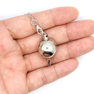Dettaglio macro di un pendolo da rabdomante in metallo solido argento lucido in mano