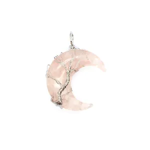 Gros plan détaillé du pendentif lune rose avec un motif d'arbre de vie argenté
