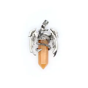 Detail of a silver-toned dragon pendant wrapped around an orange crystal pillar