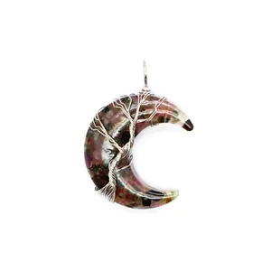 Détail du pendentif en forme de croissant de lune avec pierres et fil métallique