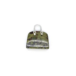 Detailansicht eines Natursteinanhängers in Form einer Mini-Handtasche als Schmuckstück.