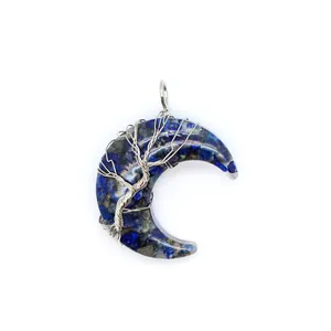 Gros plan détaillé d'un pendentif lune en lapis-lazuli bleu avec motif arbre de vie en fil