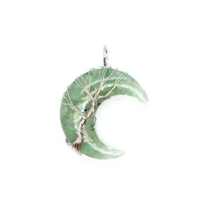 Gros plan du pendentif croissant de lune vert avec un câblage arbre de vie complexe