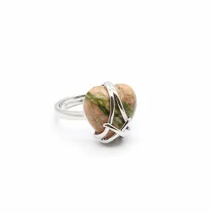 Detailed macro shot of a silver heart-shaped ring with unique pink and green unakite stone.