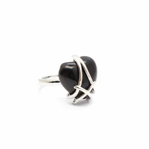 Close-up of a silver ring with a large black heart-shaped stone in a wire cage setting