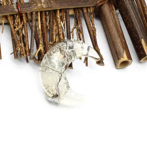 Gros plan du pendentif lune avec motif arbre de vie et éclats de cristal naturel
