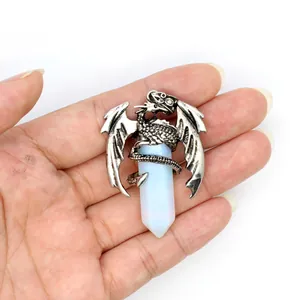 Detailed view of dragon pendant with white crystal pillar held in hand for scale.