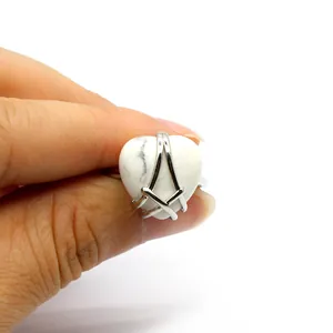Close-up macro view of the heart-shaped white stone ring with unique silver cage setting design
