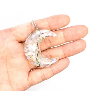 Détail d'un pendentif lune en résine avec pierres concassées et fil d'arbre de vie