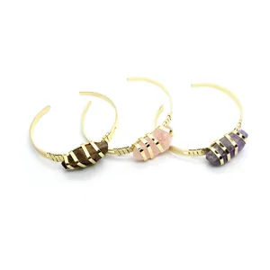Dettaglio di bracciali placcati in oro con pietre naturali di ametista e quarzo.