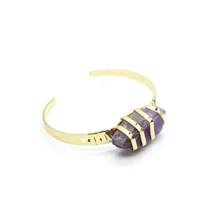 Dettaglio della pietra naturale di ametista grezza su bracciale a polsino placcato oro 24K