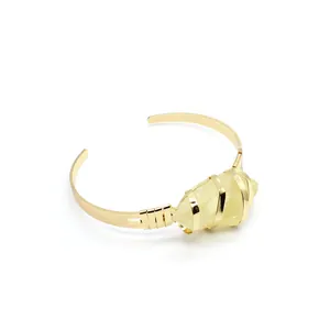 Dettaglio del bracciale rigido placcato oro 24K con pietra naturale gialla avvolta